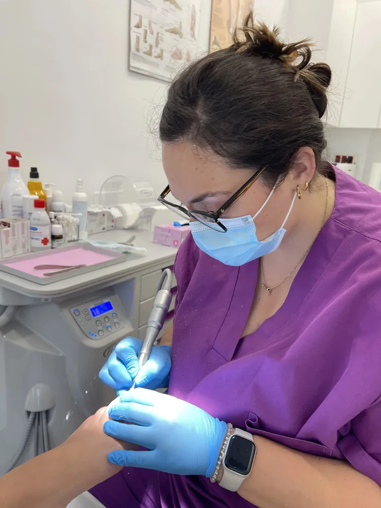 Podólogo realizando quiropodia con torno en consulta profesional